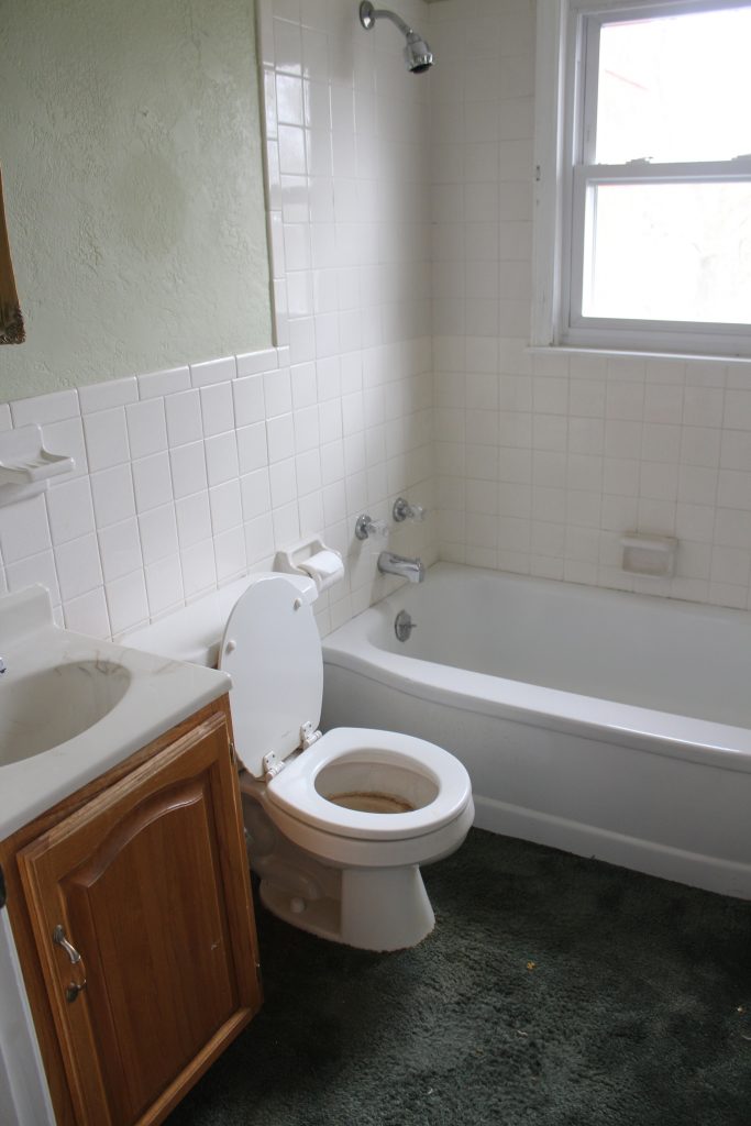 A modern farmhouse bathroom makeover - with a copper tub, copper sink, wood plank ceiling, white shiplap walls, LVT flooring, and granite counter tops.