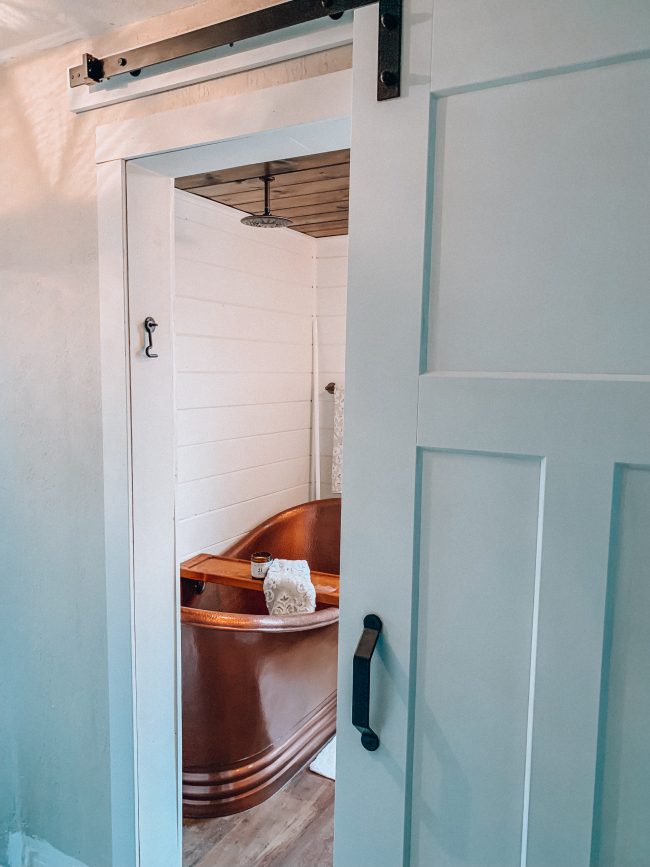 Sliding barn door on a modern farmhouse bathroom || Kansas City life, home, and style blogger Megan Wilson shares an update on her bathroom remodel || Life on Shady Lane blog