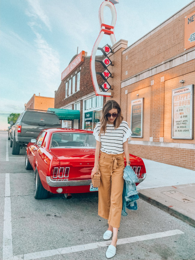 Striped ruffled top, mustard paperbag waist pants, and white mules outfit || Denim jacket outfit || Casual spring and summer style || What to do in Independence, Missouri - A guide to all the fun stuff! | Kansas City life, home, and style Blogger Megan Wilson shares a staycation trip to Independence, Missouri! #lovethesquare #staycation #visitmissouri