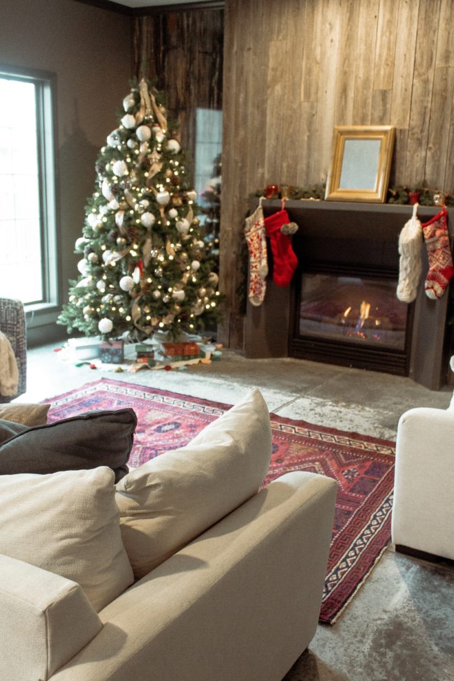 A vintage area rug in our living room || Slowly but surely decorating our new home! || Kansas City life, home, and style blogger Megan Wilson shares a peek at a new rug in her home's living room // concrete floors, vintage area rug, Christmas tree, fireplace 