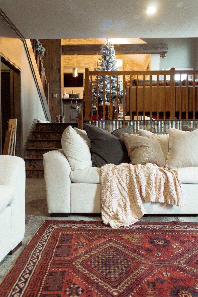 A vintage area rug in our living room || Slowly but surely decorating our new home! || Kansas City life, home, and style blogger Megan Wilson shares a peek at a new rug in her home's living room // concrete floors, vintage area rug, Christmas tree, fireplace 