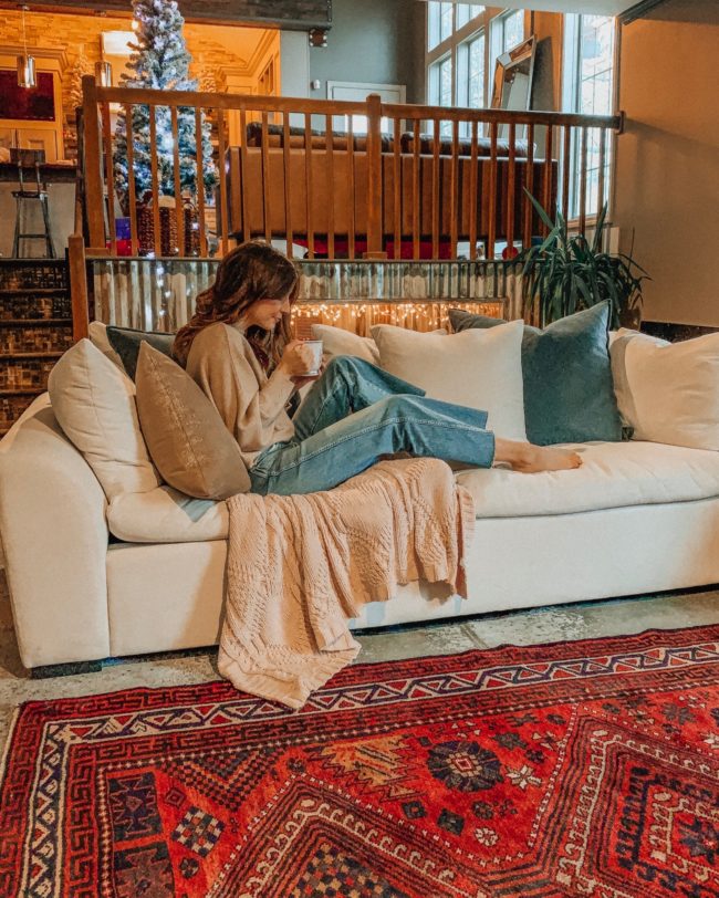A vintage area rug in our living room || Slowly but surely decorating our new home! || Kansas City life, home, and style blogger Megan Wilson shares a peek at a new rug in her home's living room // concrete floors, vintage area rug, Christmas tree, fireplace 