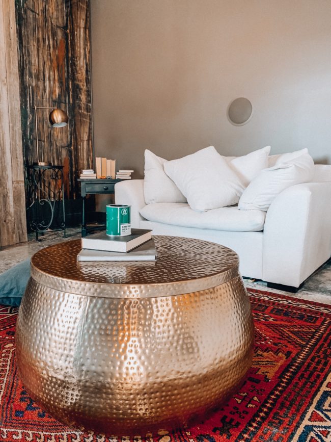 A unique, hammered gold coffee table WITH STORAGE! || Kansas City life, home, and style blogger Megan Wilson shares an update to her living room