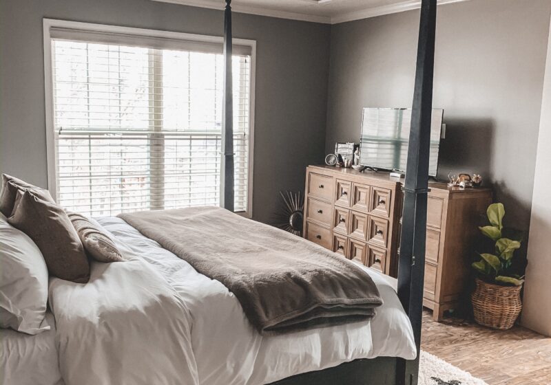 Black and white area rug in master bedroom, white bedding, black four poster bed || Neutral master bedroom design, plus the plans we have to change things up! Kansas City life, home, and style blogger Megan Wilson shares her master bedroom design plans and inspiration