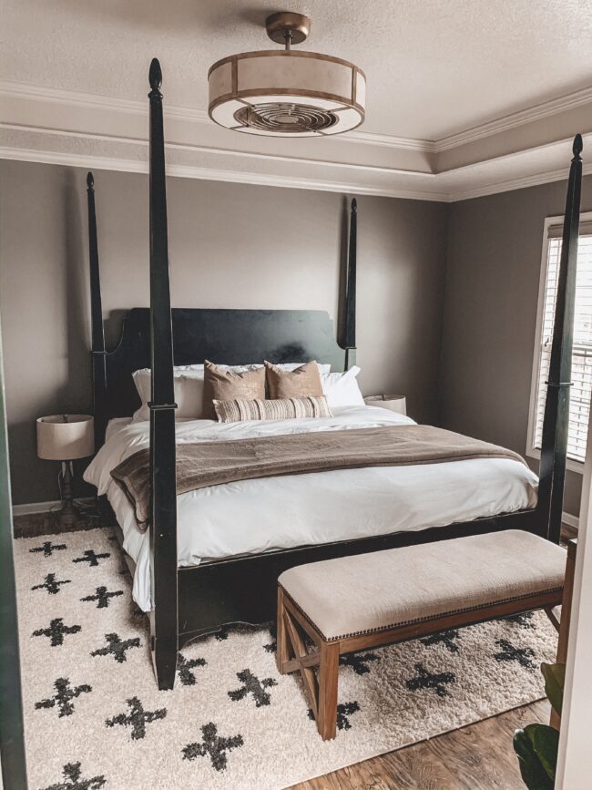 Black and white area rug in master bedroom, white bedding, black four poster bed || Neutral master bedroom design, plus the plans we have to change things up! Kansas City life, home, and style blogger Megan Wilson shares her master bedroom design plans and inspiration