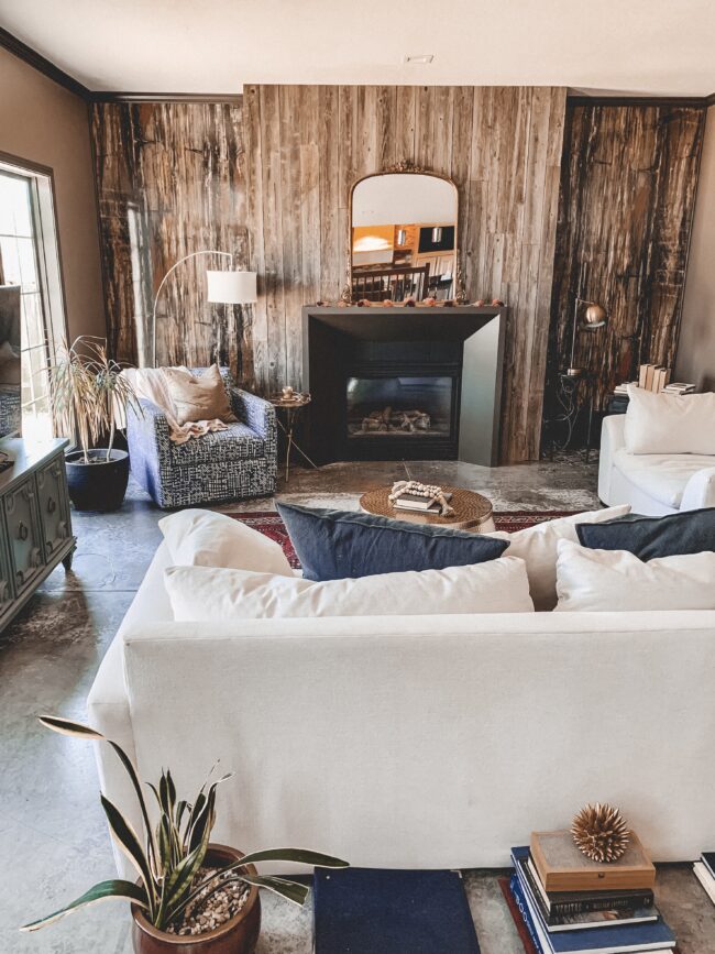 Gold Mirror over the Fireplace in the Living Room, white couch, wood planked fireplace wall || Kansas City life, home, and style blogger Megan Wilson shares a living room update