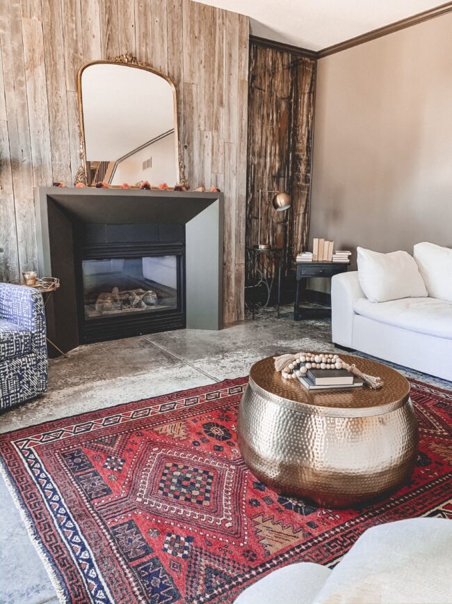 Gold Mirror over the Fireplace in the Living Room, gold hammered metal coffee table, black modern fireplace, white couch, wood planked fireplace wall || Kansas City life, home, and style blogger Megan Wilson shares a living room update