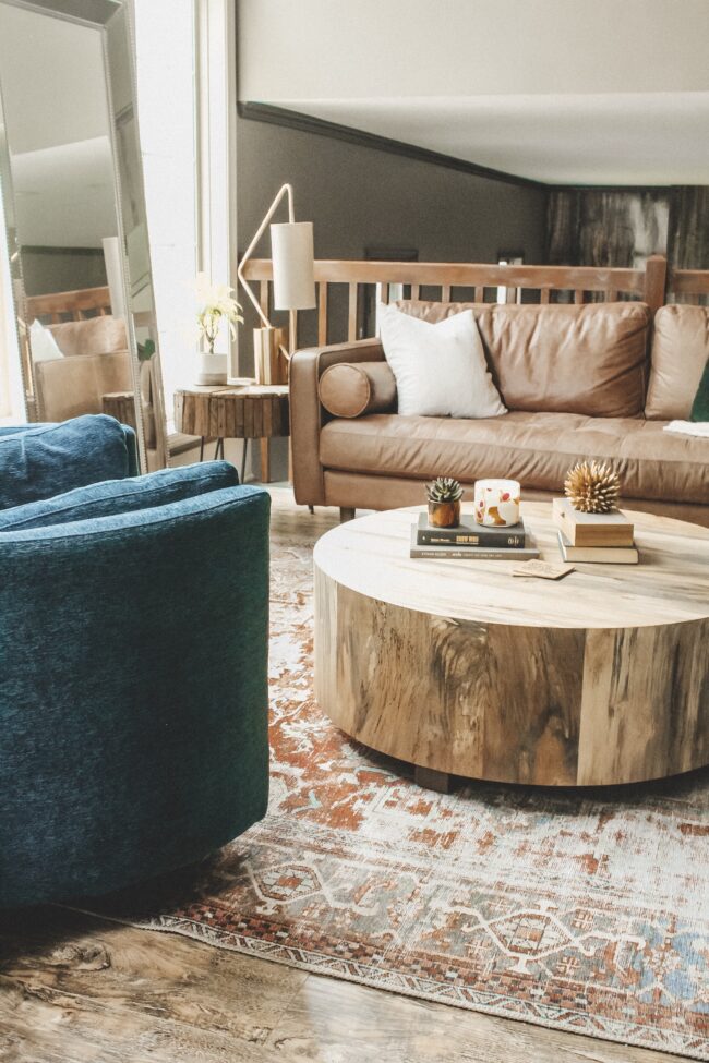 Home Tour: our living room makeover!! Kansas City life, home, and style blogger Megan Wilson shares how she refreshed her living room with matching recliners, a turkish-inspired area rug, round coffee table, distressed wood side table, unique table lamp, and leather couch