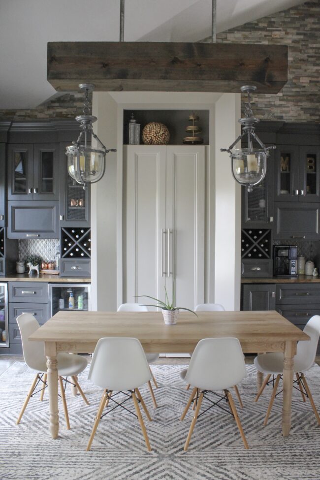 Light wood anthropologie dining table and white chairs, rug in dining room || Dining room inspiration || Kansas City life, home, and style blogger Megan Wilson shares a tour of her home, recently featured in Kansas City magazine