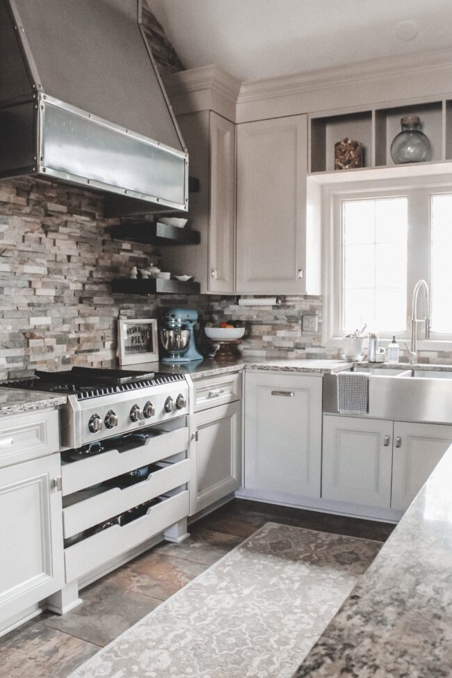 Rustic meets modern kitchen, stone backsplash, stainless steel range hood || Kitchen inspiration || Kansas City life, home, and style blogger Megan Wilson shares a tour of her home, recently featured in Kansas City magazine