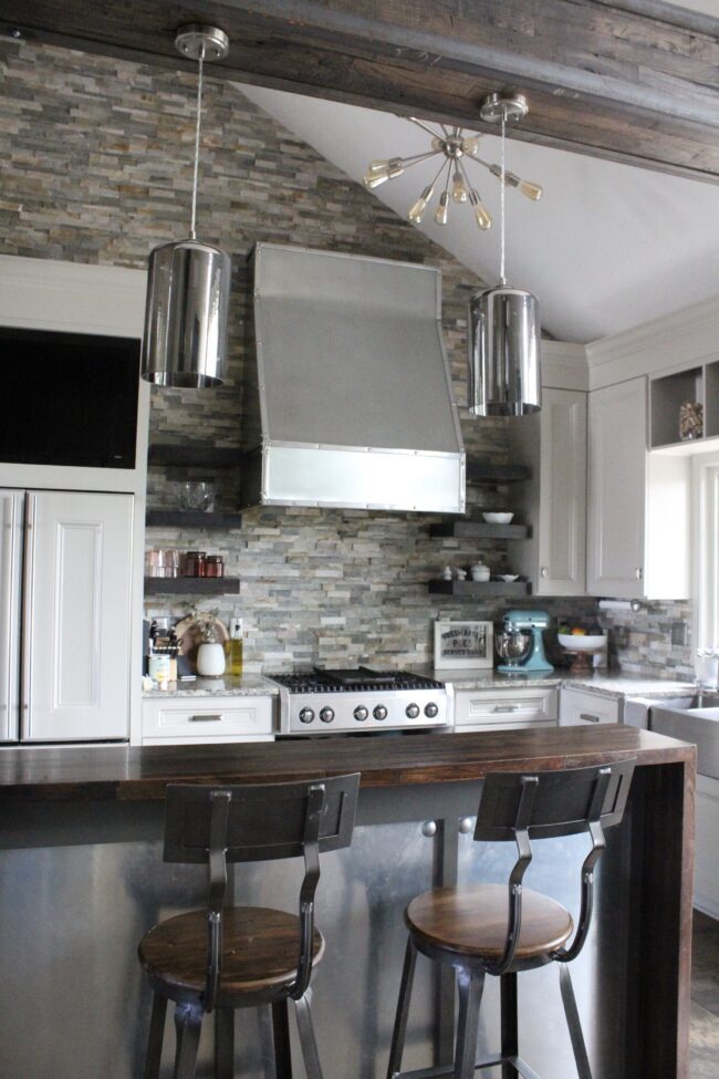 Rustic meets modern kitchen, stone backsplash, stainless steel range hood || Kitchen inspiration || Kansas City life, home, and style blogger Megan Wilson shares a tour of her home, recently featured in Kansas City magazine