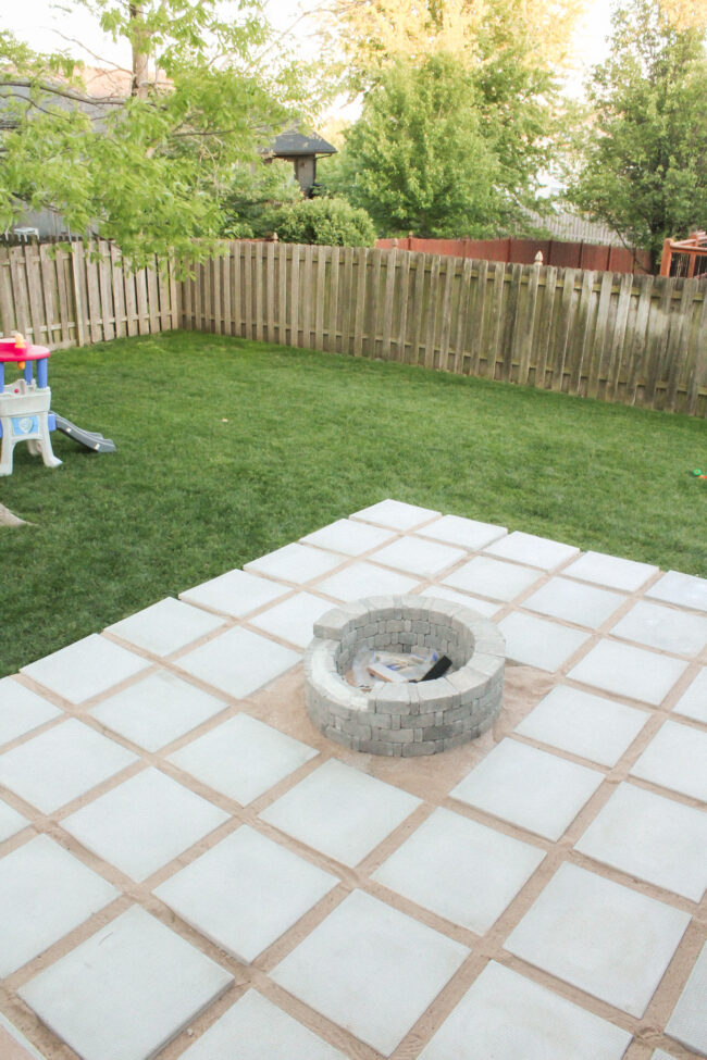 DIY patio with grass between pavers and a fire pit!